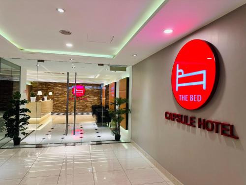 a hotel lobby with a red circle hotel sign on the wall at The Bed Bukit Bintang in Kuala Lumpur