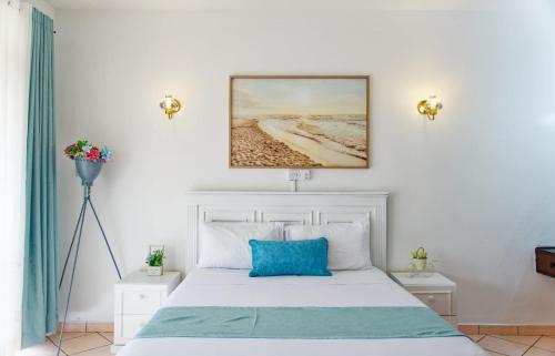 1 dormitorio con cama blanca y almohada azul en Luxury 2 bedroom, en Ukunda