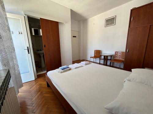 una camera da letto con un grande letto bianco e un tavolo di Marina a Vela Luka (Vallegrande)