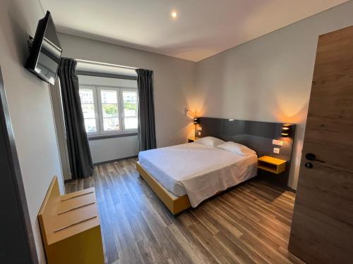 ein Schlafzimmer mit einem Bett und einem TV. in der Unterkunft Fonte Luminosa in Lissabon