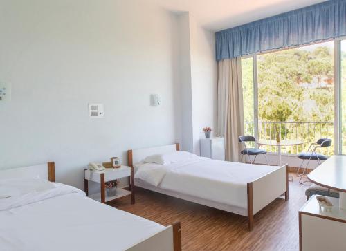 ein Hotelzimmer mit 2 Betten und einem Balkon in der Unterkunft Merry Land Hotel in Bharsaf