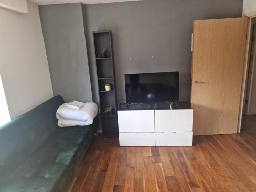 um quarto com uma cama e uma grande televisão em Immaculate 1-Bed Apartment in London em Londres