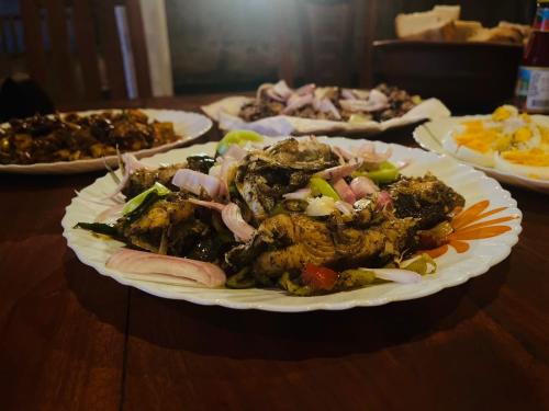 a plate of food on a table with plates of food at BAWANS VILLA Holiday Home for Family or Group in Hikkaduwa
