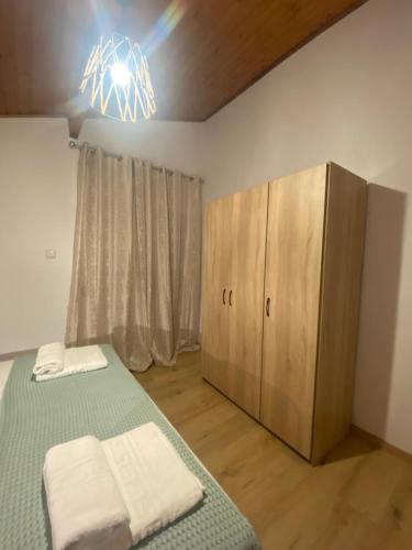 a bedroom with a bed and a wooden cabinet at Blue View in Kavala