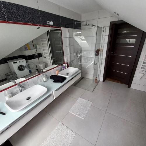 een badkamer met 2 wastafels en een inloopdouche bij Castell 