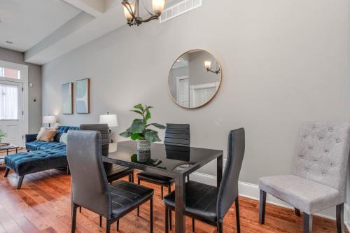 a dining room with a table and chairs and a mirror at Historic Benton Park Townhome in Soulard