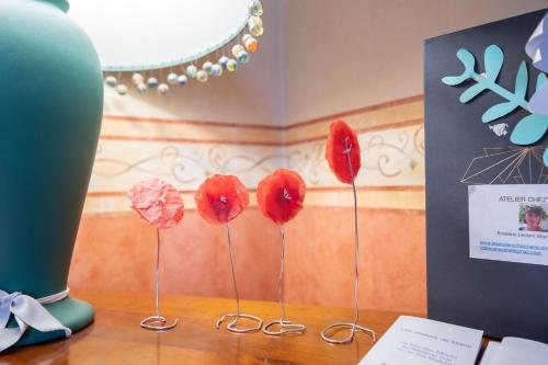 a group of red flowers on a wooden table at Atelier chez Marie in Carnetin