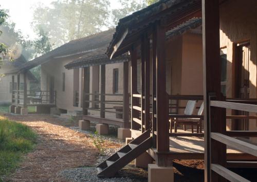 a row of wooden buildings with a path leading to them at Tiger Tops Karnali Lodge in Bardia
