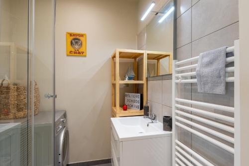 une salle de bain avec un lavabo et une machine à laver dans l'établissement Standing Vieux port 110 m2, Marseille, à Marseille