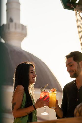 a man and a woman holding drinks in their hands at DECAN Concept Boutique Estate in Rhodes Town