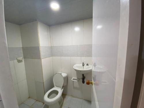 Apartahotel Saroa في Fonseca: حمام صغير مع مرحاض ومغسلة