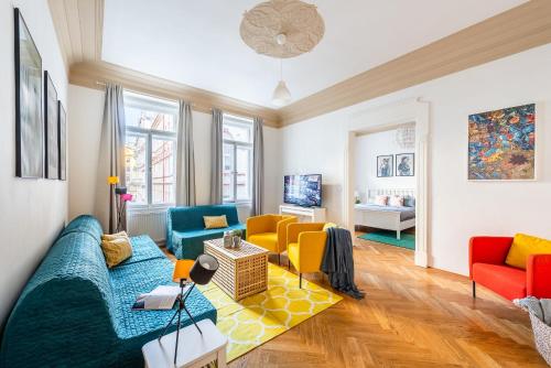 sala de estar con sofá azul y sillas amarillas en GRAND DELUXE ViP APARTMENT en Praga