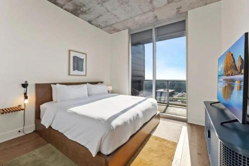 a bedroom with a large bed and a large window at NEW 1BR Scenic Retreat with Rooftop pool on Rainey St in Austin