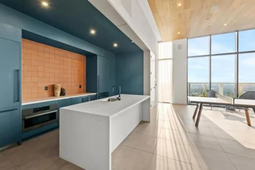 a kitchen with a white sink and blue walls at NEW 1BR Scenic Retreat with Rooftop pool on Rainey St in Austin