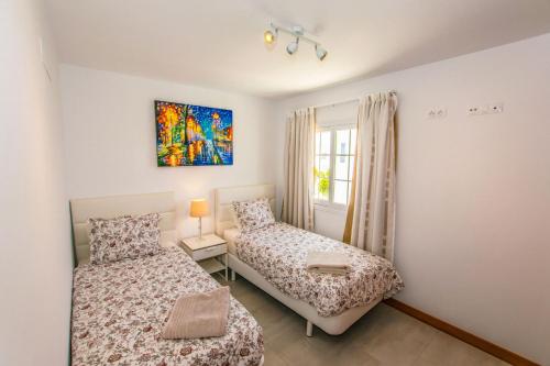 um quarto com 2 camas e uma janela em 228 - Casa Luca by Villas Now Ltd em Playa Blanca