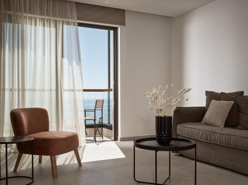 a living room with a couch and a chair and a table at Salita - Comfort Living Apartments in Zakynthos Town