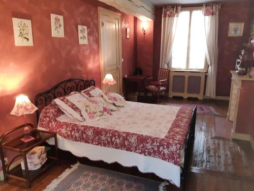 La BouilleにあるLA BOUILLOIRE, demeure historique et de caractère du 19è siècle.の赤い壁のベッドルーム1室(大型ベッド1台付)
