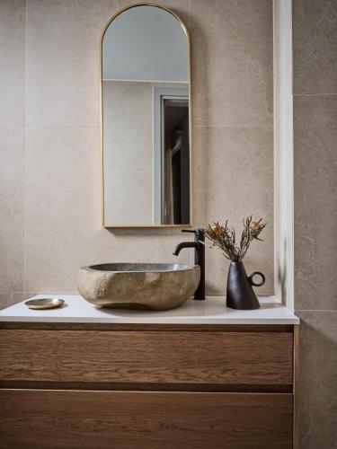 a bathroom with a stone sink and a mirror at Salita - Comfort Living Apartments in Zakynthos Town