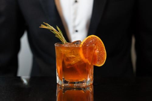 a man in a suit and a drink with an orange slice at Square Townhouse in Brighton & Hove