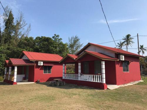 une maison rouge avec un toit rouge dans l'établissement Mersing Chalet Teluk Sisek, 