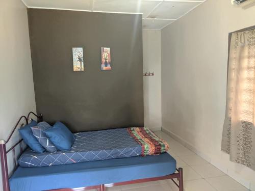 a small bedroom with a blue bed in a room at Mersing Chalet Teluk Sisek in Kampong Sisek