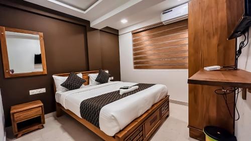 1 dormitorio con 1 cama grande con marco de madera en EMERALD INN, en Kochi