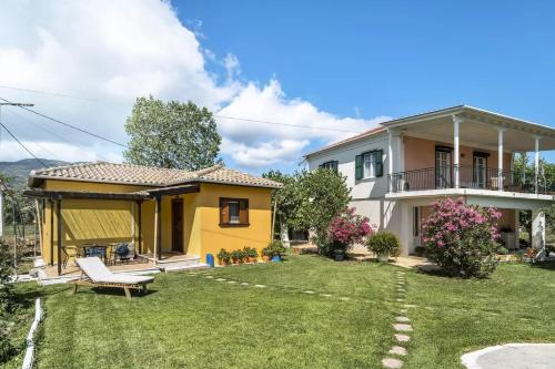 a house with a yard with a yellow house at Garden House Lefkada in Lygia
