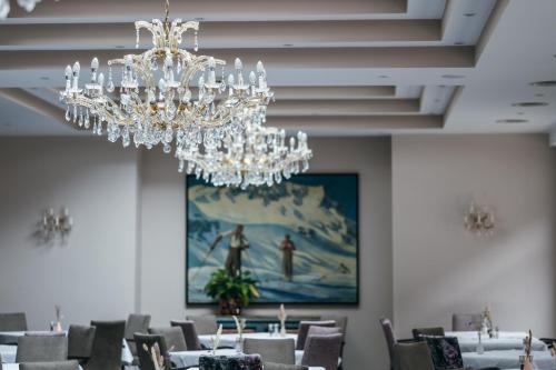 a dining room with tables and a chandelier at Hotel Post in Sankt Anton am Arlberg