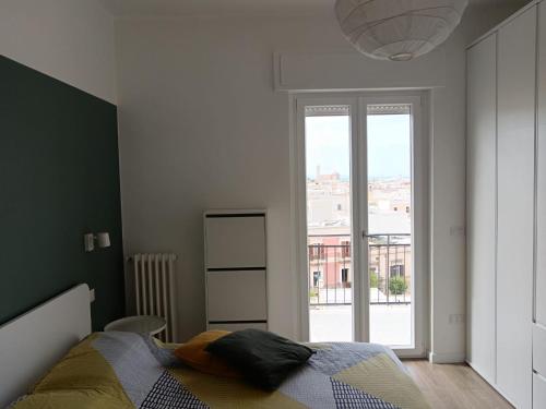 a bedroom with a bed and a large window at La casetta di Cecilia in Trani