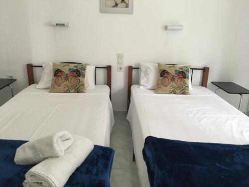 2 Betten in einem Zimmer mit Handtüchern darauf in der Unterkunft Bay Apartments - Kalami by Sunvil in Kalámi