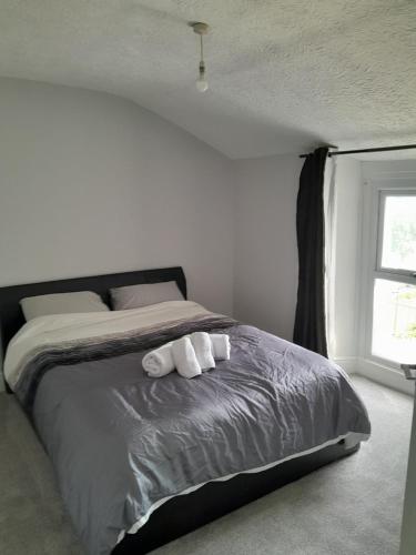 a bedroom with a bed with two towels on it at Conveniently located, newly refurbished flat (sleeps 4) in Pembrokeshire