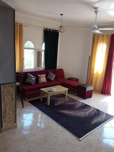 a living room with a red couch and a table at الغردقه البحر الاحمر مبارك 6 in Hurghada