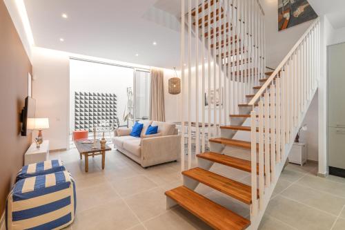 Una escalera de caracol en una sala de estar con un sofá. en Calella Apartments by Olala Homes, en Calella