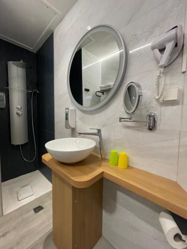a bathroom with a sink and a mirror at Le Strasbourg Hotel in Montpellier