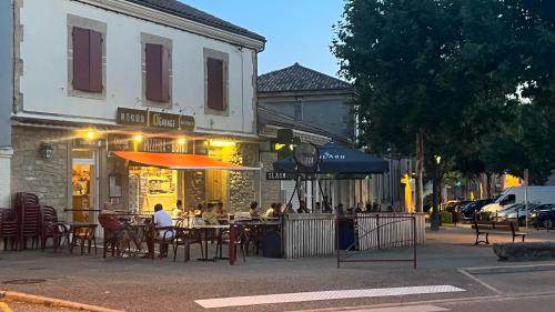 a restaurant with tables and umbrellas on a city street at Maison privée style provençal in Grane