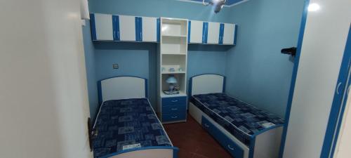 a small room with two beds and a shelf at Appartement face à la Mer in Mrarech
