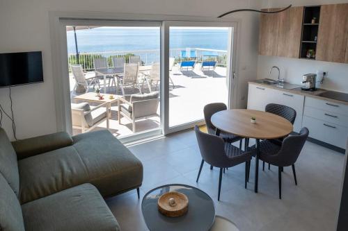 a living room with a couch and a table with chairs at Villa Fertilia - Key to Villas in Fertilia