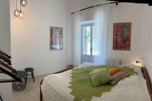 a bedroom with a bed with green pillows on it at Forca de Cerro in Spoleto