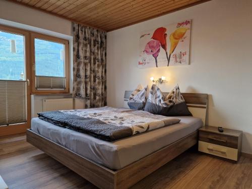 a bedroom with a bed and a large window at Haus Höllerer in Uttendorf