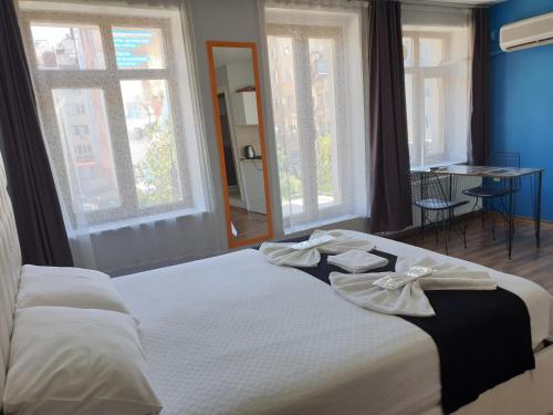 1 dormitorio con 1 cama con sábanas blancas y ventanas en Seven Suite Taksim en Estambul