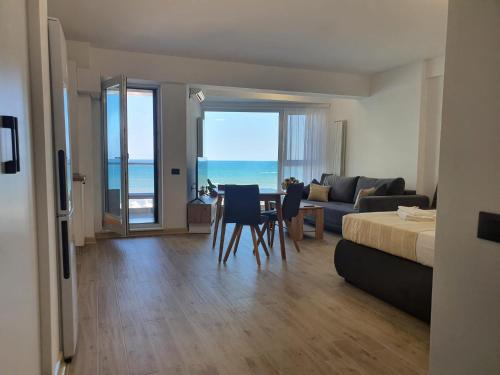 a living room with a bed and a table and chairs at Alee Infinity Pool & Spa in Mamaia Sat/Năvodari