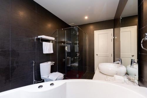La salle de bains est pourvue d'une baignoire, de toilettes et d'un lavabo. dans l'établissement villa long cung gần biển 7 phòng ngủ VIP, à Vung Tau
