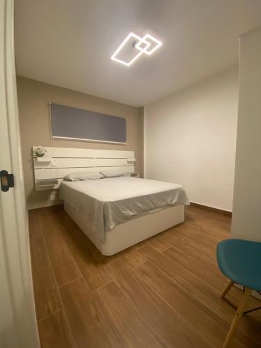 1 dormitorio con 1 cama blanca y TV en Casa Morena en Costa de Antigua