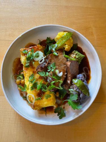 a bowl of food with meat and vegetables on a table at Grand Hôtel & Kurhaus in Arolla