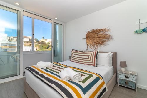 a bedroom with a bed and a large window at Casa Ayla in Carvoeiro