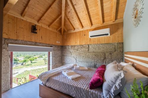 ein Schlafzimmer mit einem Bett und einem großen Fenster in der Unterkunft Quinta das Carvoeiras in Vieira do Minho