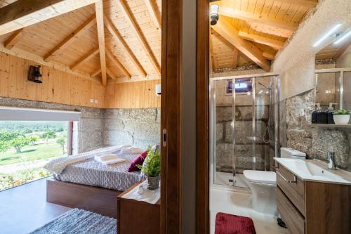米尼奧河畔維埃拉的住宿－Quinta das Carvoeiras，一间卧室配有一张床、一个浴缸和一个水槽