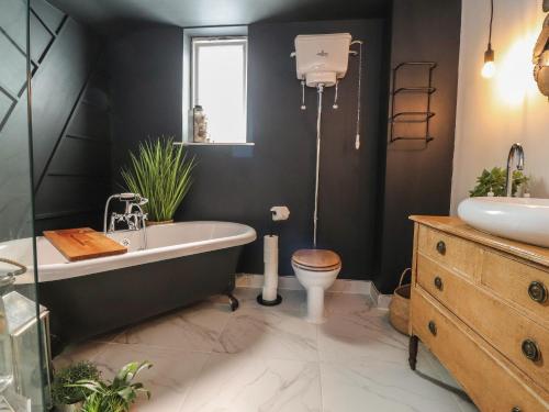 a bathroom with a tub and a toilet and a sink at Dunster Cottage in Clitheroe