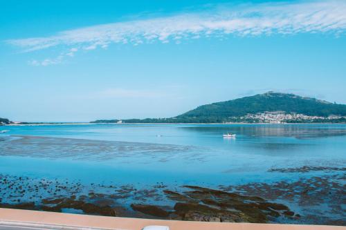 una vista de un cuerpo de agua con un barco dentro en Just Like Home - Apê do Rio, en Caminha