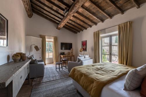 a bedroom with a large bed and a living room at Les Petites Maisons - Hameau des Baux in Paradou